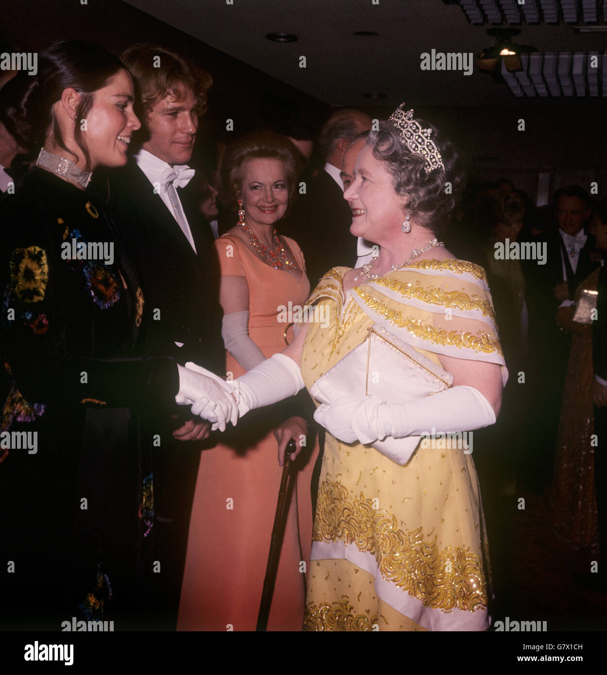 Reina Elizabeth La Reina Madre se reúne (l-r) Ali MacGraw, Ryan O'Neal y Olivia de Havilland en la actuación de Cine Real de Love Story en el Odeon, Leicester Square. Foto de stock