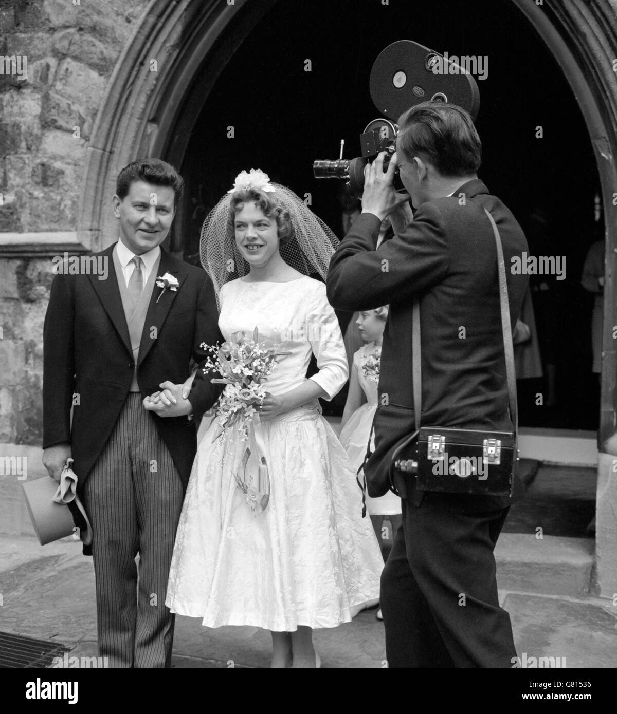 Richard Baker es filmado para la televisión cuando se va con su novia, anteriormente Margaret Martin, después de su boda en la iglesia de St Mary the Boltons en Kensington, Londres. Foto de stock