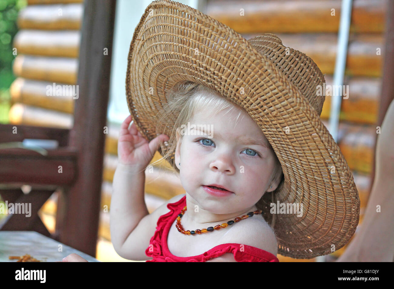 Hermoso bebé girle con ojos azules vistiendo sombrero paja Fotografía de stock - Alamy