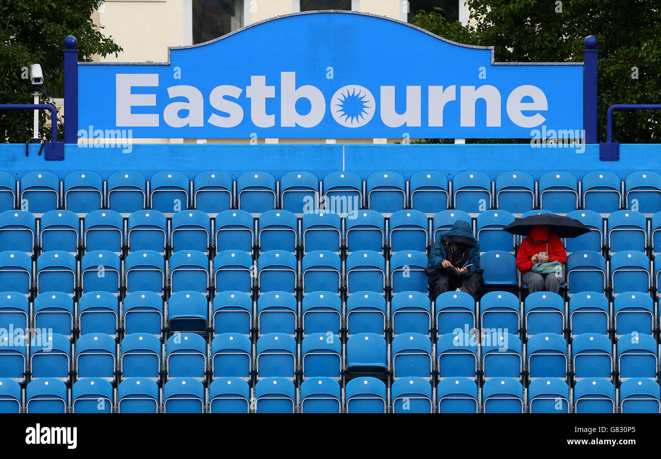 Los espectadores se sientan en el stand mientras llueve retrasa el juego durante el tercer día de AEGON International en Devonshire Park, Eastbourne. ASOCIACIÓN DE PRENSA Foto. Fecha del cuadro: Lunes 22 de junio de 2015. Ver historia de PA TENIS Eastbourne. El crédito de la foto debe decir: Gareth Fuller/PA Wire Foto de stock