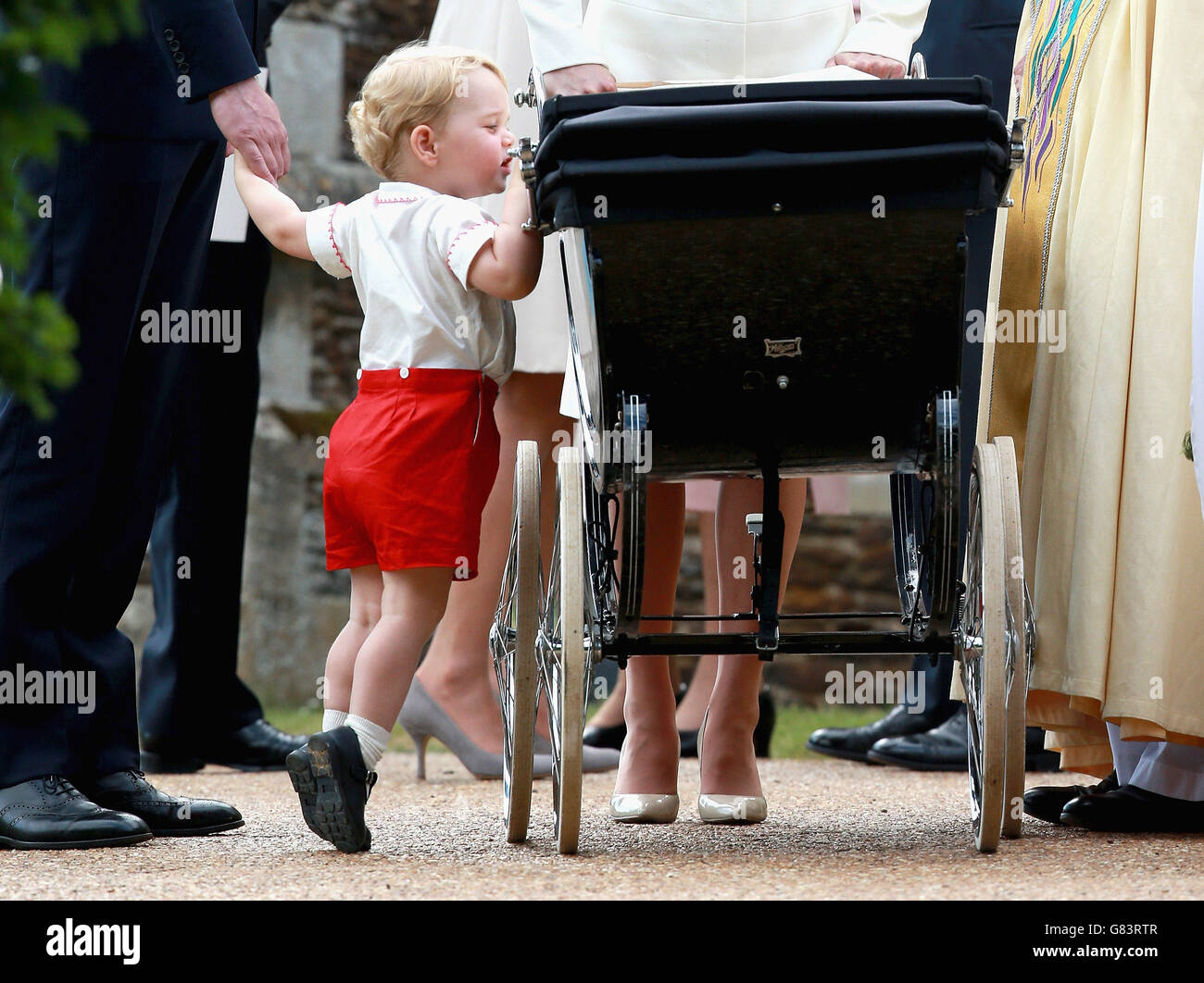 El Príncipe Jorge mira a su hermana la Princesa Charlotte mientras salen de la Iglesia de Santa María Magdalena en Sandringham, Norfolk. Foto de stock