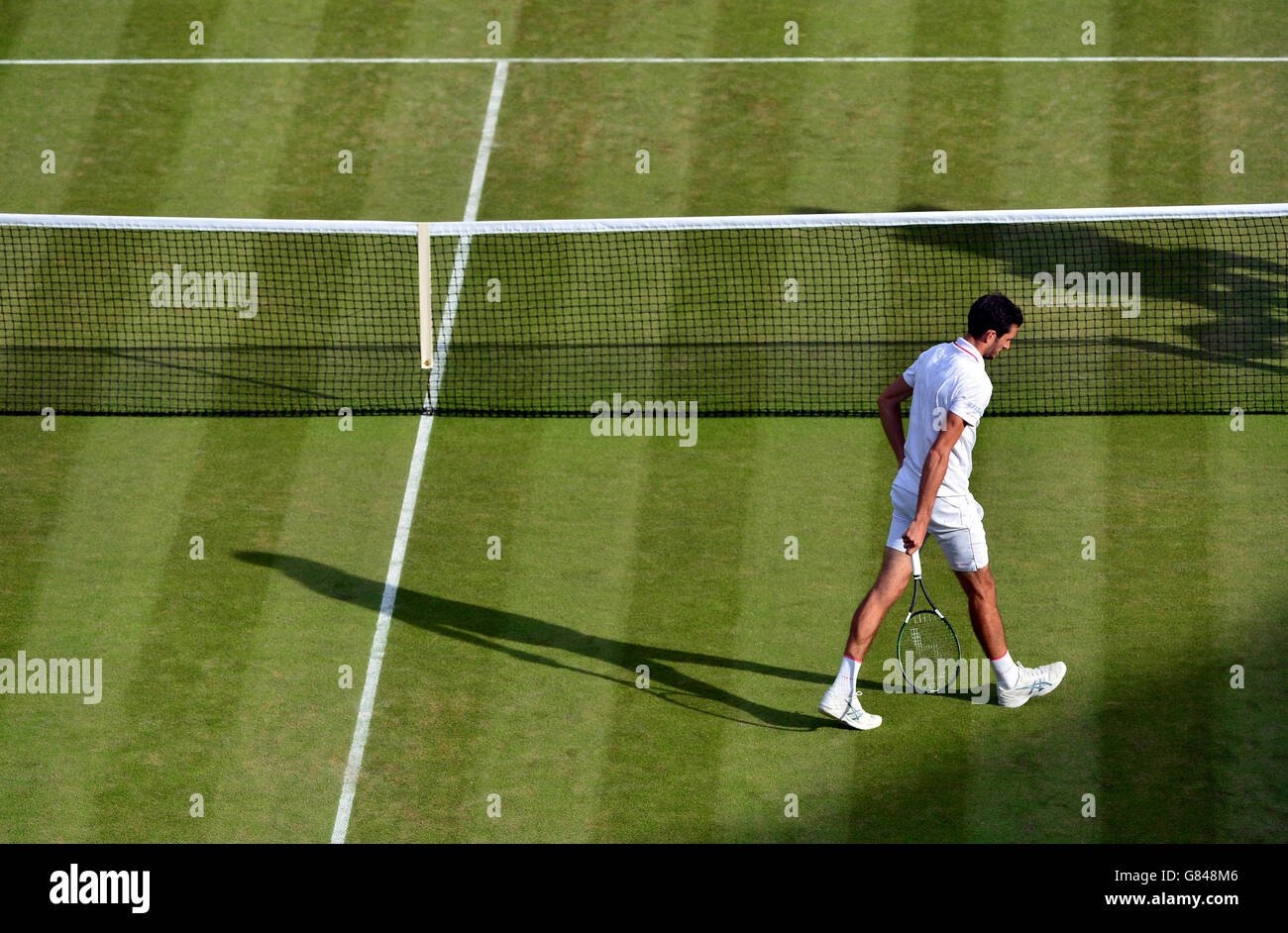 James Ward deja su servicio contra Vasek Pospisil durante el sexto día del Campeonato de Wimbledon en el All England Lawn Tennis and Croquet Club, Wimbledon. Foto de stock