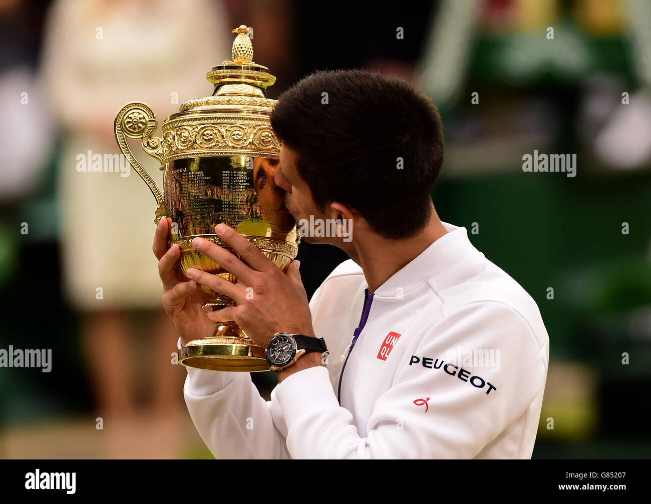 Novak Djokovic con el trofeo después de vencer a Roger Federer en la final Mens Singles el día trece del Campeonato de Wimbledon en el All England Lawn Tennis and Croquet Club, Wimbledon. Foto de stock