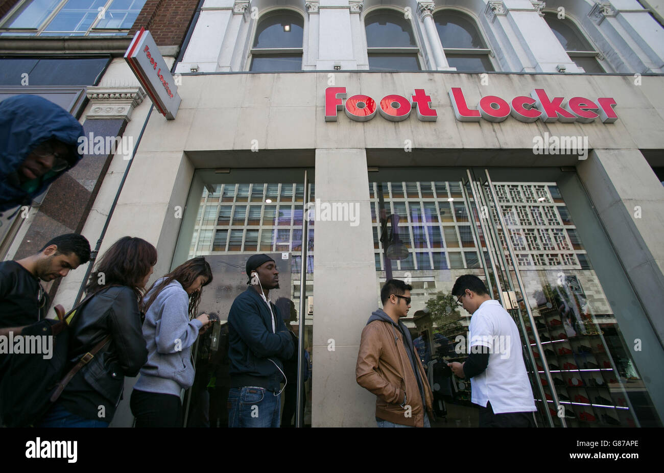 La hace cola fuera de Foot Locker Street, Londres, para comprar un par de entrenadores Adidas Boost 350, diseñados por el músico Kanye West Fotografía de stock - Alamy