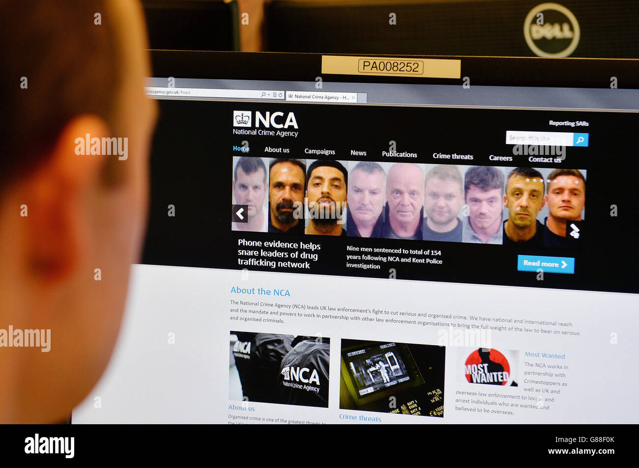 Un hombre mira el sitio web de la Agencia Nacional del crimen después de que fue atacado por hackers en un aparente ataque de venganza. Foto de stock