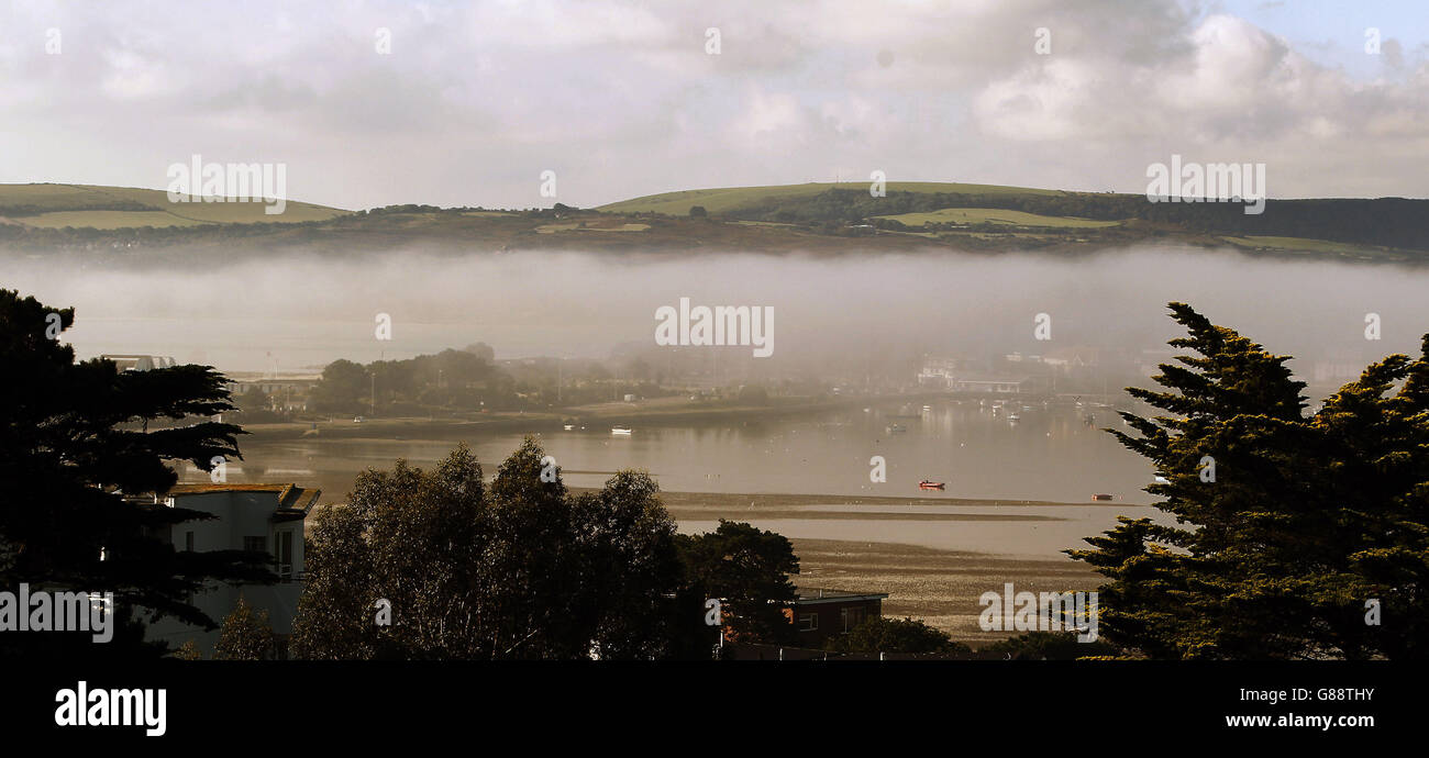 Niebla baja sobre Sandbanks en la entrada del puerto de Poole en Dorset, envuelve las colinas de Purbeck en la distancia. Foto de stock