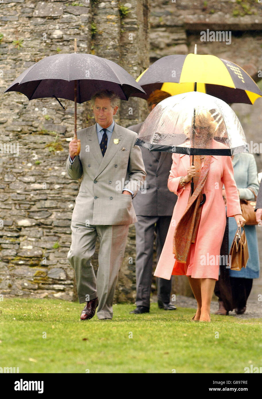El Príncipe de Gales y la Duquesa de Cornualles se refugian bajo paraguas  después de recorrer el castillo de Restormel en ruinas Fotografía de stock  - Alamy