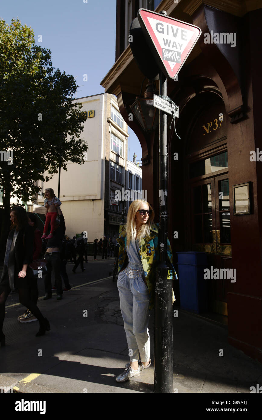 Street Style Fashion - London Fashion Week 2015. Una mujer se inclina contra un poste de lámpara fuera del BFC Show Space en el aparcamiento Brewer Street en Soho, Londres. Foto de stock