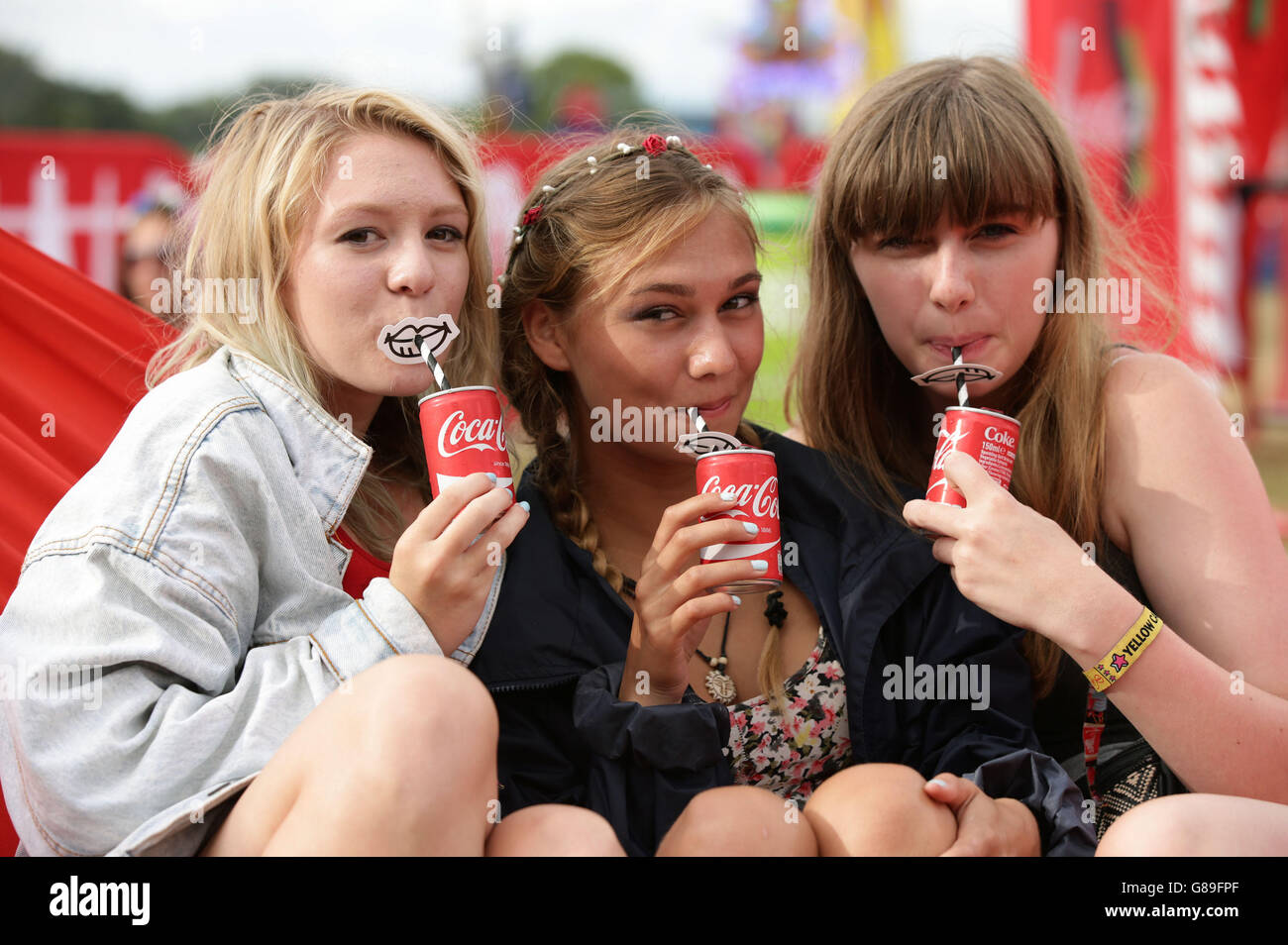 Los visitantes del festival disfrutan de una bebida en una hamaca en la  zona de Coca-Cola Share a Coke Party POD, en el V Festival en Hylands Park  en Chelmsford, Essex Fotografía