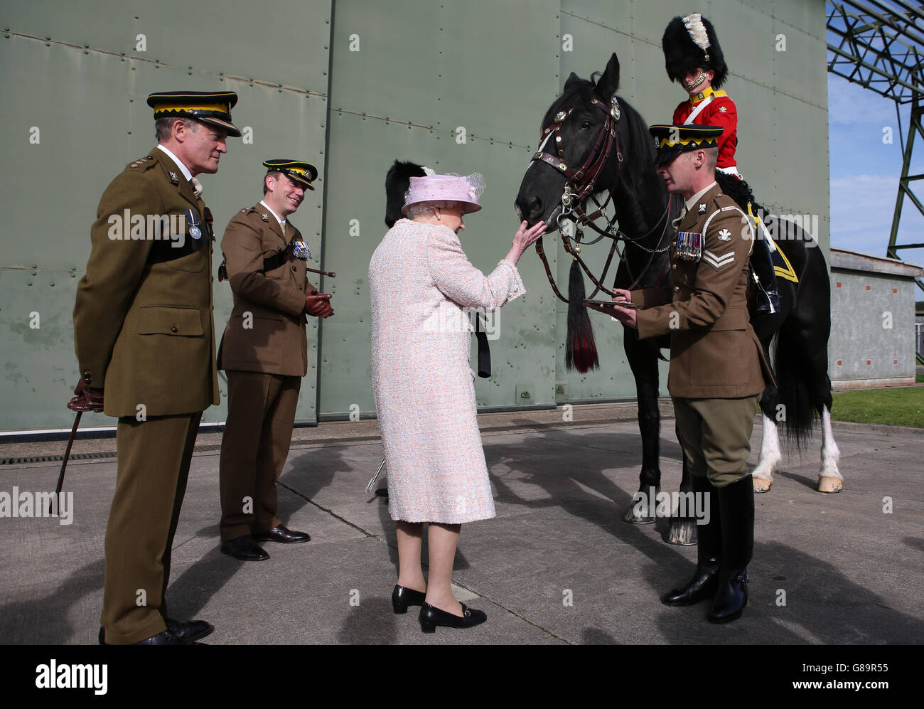 La Reina alimenta a Talavera, el caballo de tambor regimental, durante una visita a la Guardia Real de Dragones escoceses en la Estación de Leuchars. Foto de stock