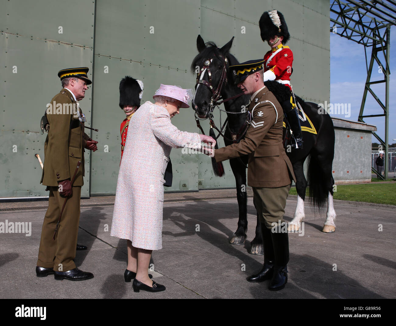 La Reina alimenta a Talavera, el caballo de tambor regimental, durante una visita a la Guardia Real de Dragones escoceses en la Estación de Leuchars. Foto de stock