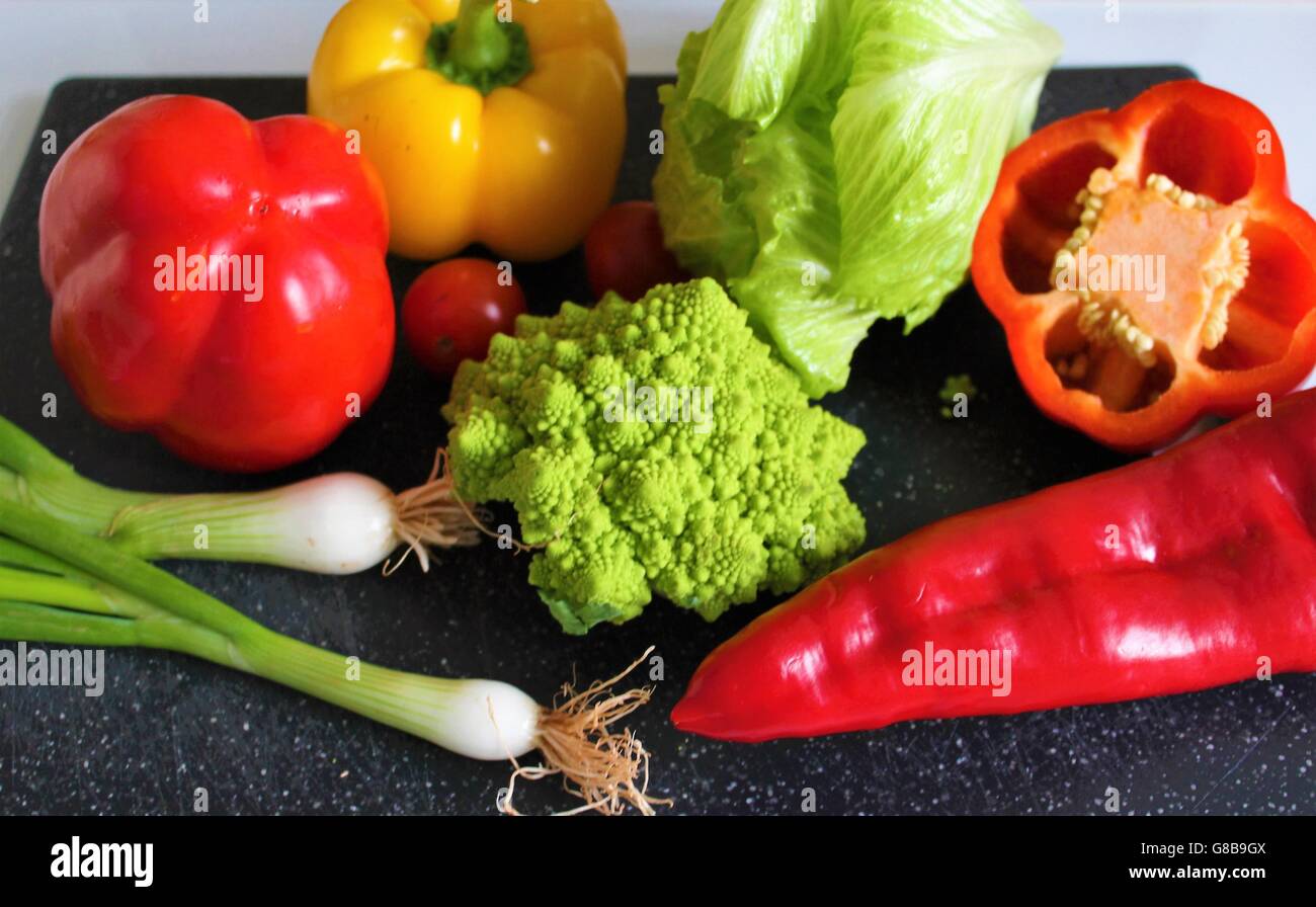 Vibrante, colorida, verdura fresca, incluida la romanesco pimientos, brócoli, cebolletas y lechuga. Foto de stock
