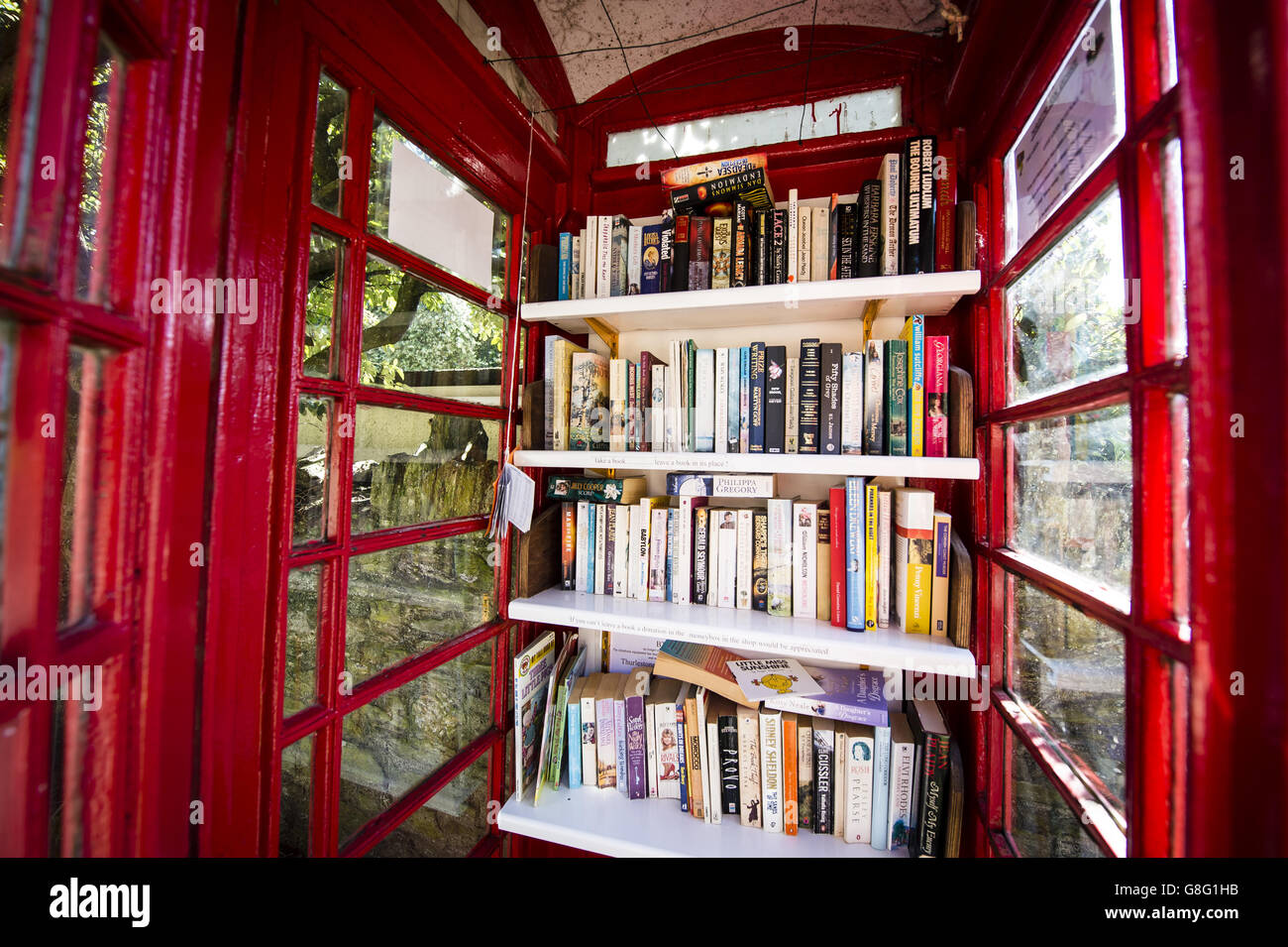 Una vieja caja de teléfono roja convertida en un intercambio de libros en el pueblo de Thurlestone, Devon. PRENSA FOTO DE ASOCIACIÓN. Fecha de la foto: 26 de septiembre de 2015. El crédito de la foto debe ser: Ben Birchall Foto de stock
