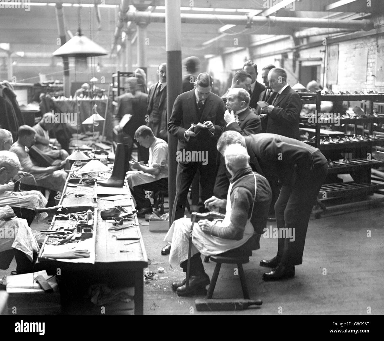 El Duque de York examina el trabajo de un miembro del personal de 80 años en la fábrica de botas de Crockett & Jones en Northampton. Foto de stock