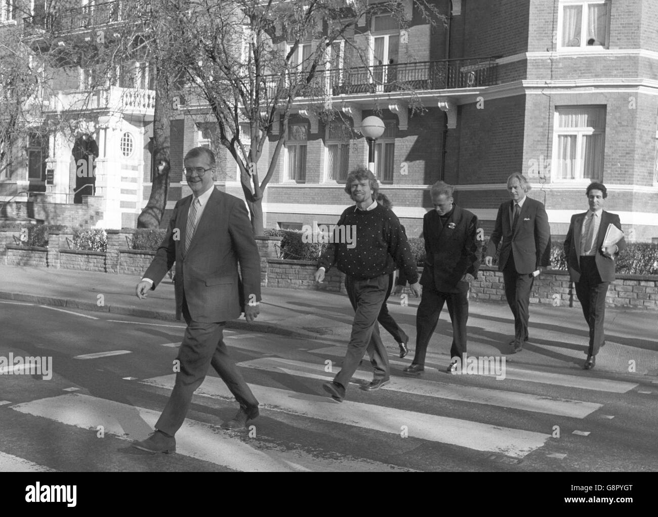 Siguiendo los pasos de los Beatles en el cruce de cebra de Abbey Road están (l-r) el secretario de educación Kenneth Baker, el magnate discográfico Richard Branson, Matt Goss del grupo pop Bros, el productor de discos George Martin y Mark Featherstone-witty, fundador de la London School of Performing Arts and Technology. La escuela, que se abrirá en Croydon en 1990, será financiada por el recientemente creado British Record Industry Trust y el departamento de Educación. Foto de stock