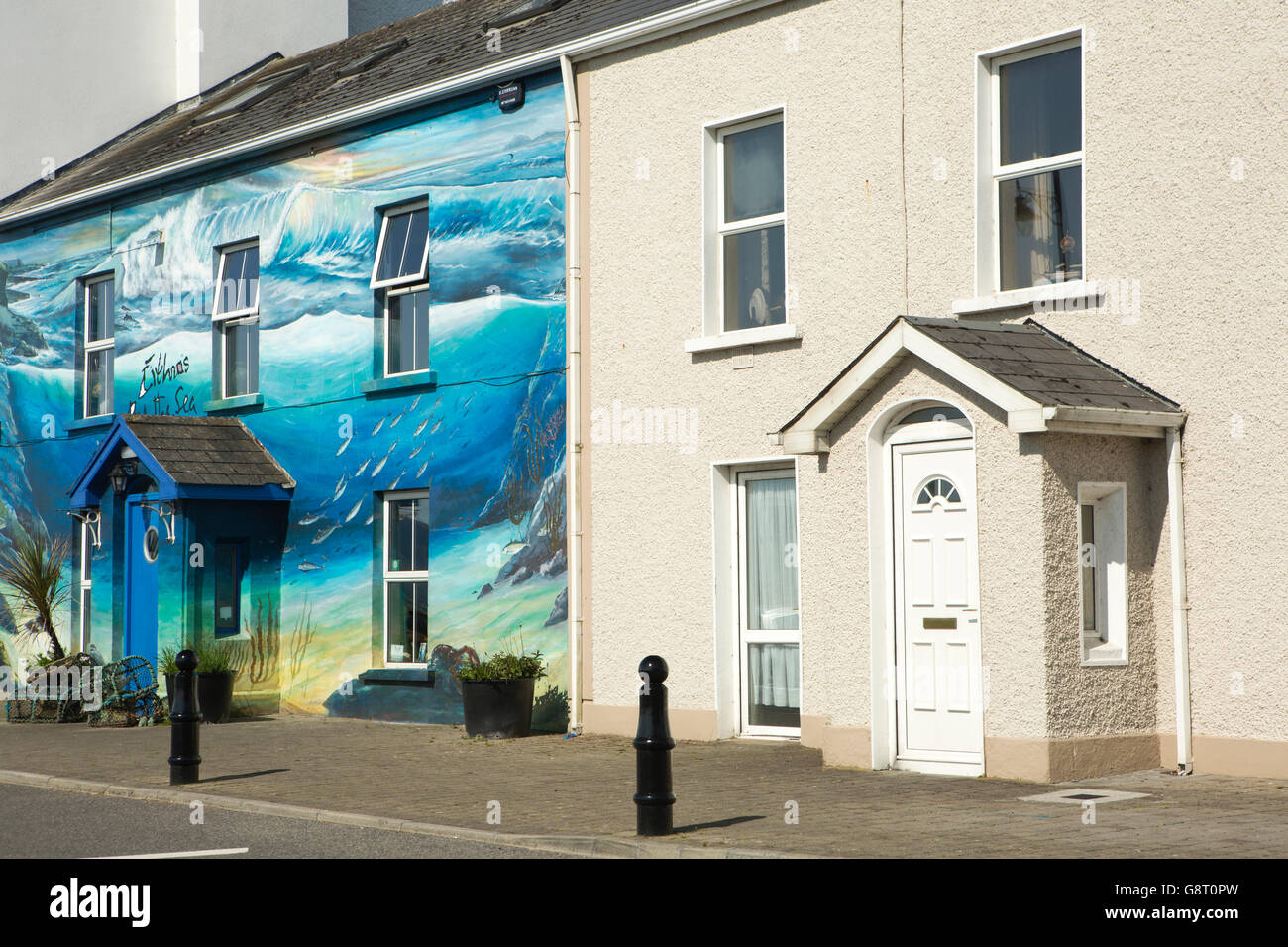 Irlanda, Co Sligo, Eithnas Mullaghmore, Puerto, junto al mar, restaurante de mariscos con frontales pintadas junto al vecino sin pintar Foto de stock