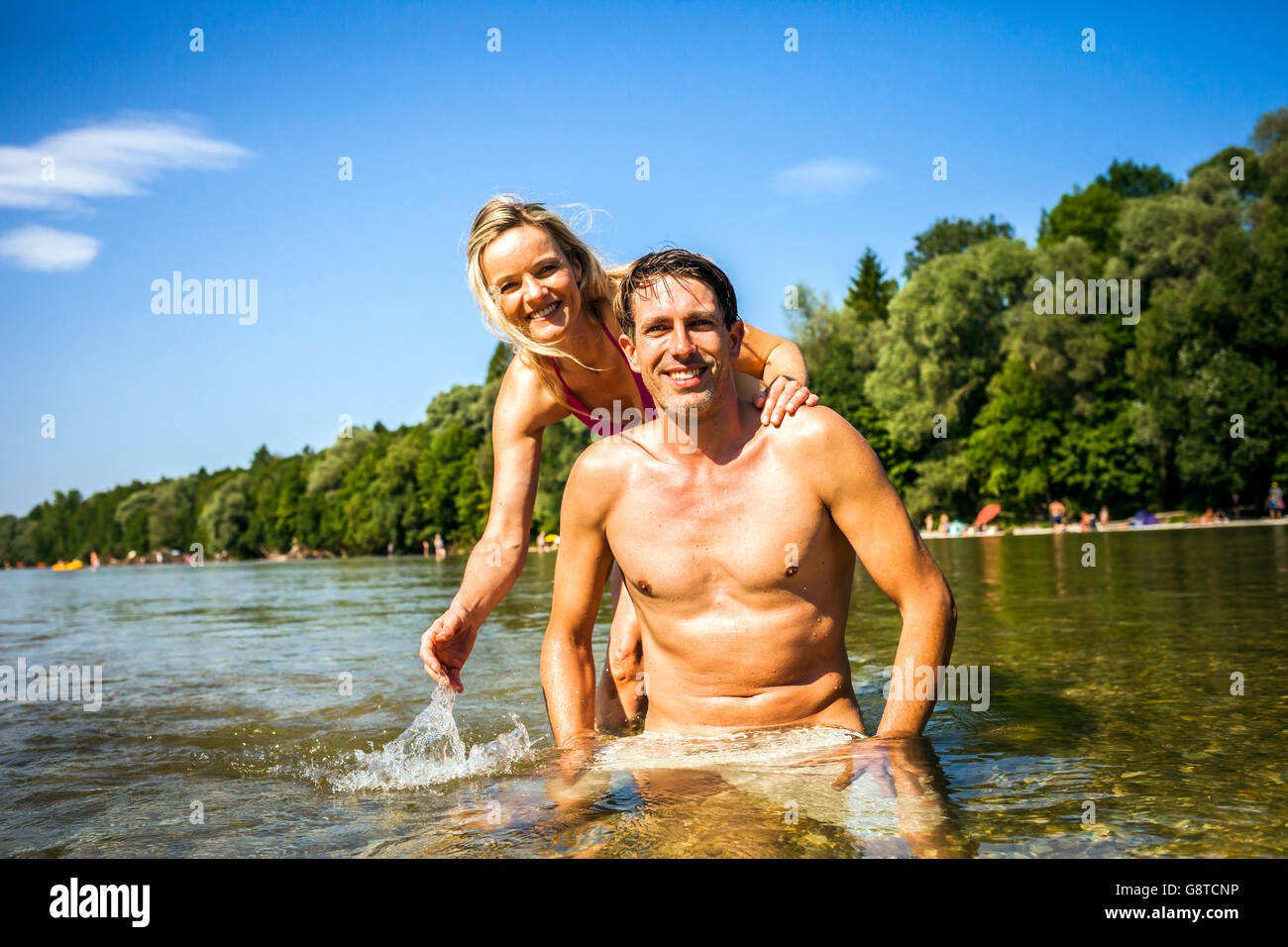 Feliz pareja abrazada en el río, las estribaciones de los Alpes de Baviera, Alemania Foto de stock