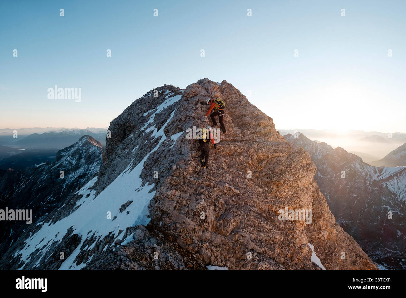 Dos montañeros la escalada en el pico de la montaña en los Alpes Foto de stock