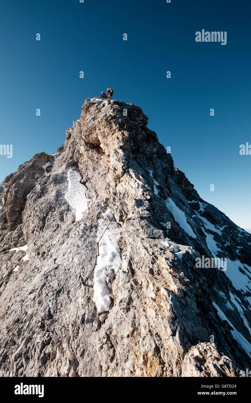 Dos montañeros de pie sobre el pico de la montaña en los Alpes Foto de stock