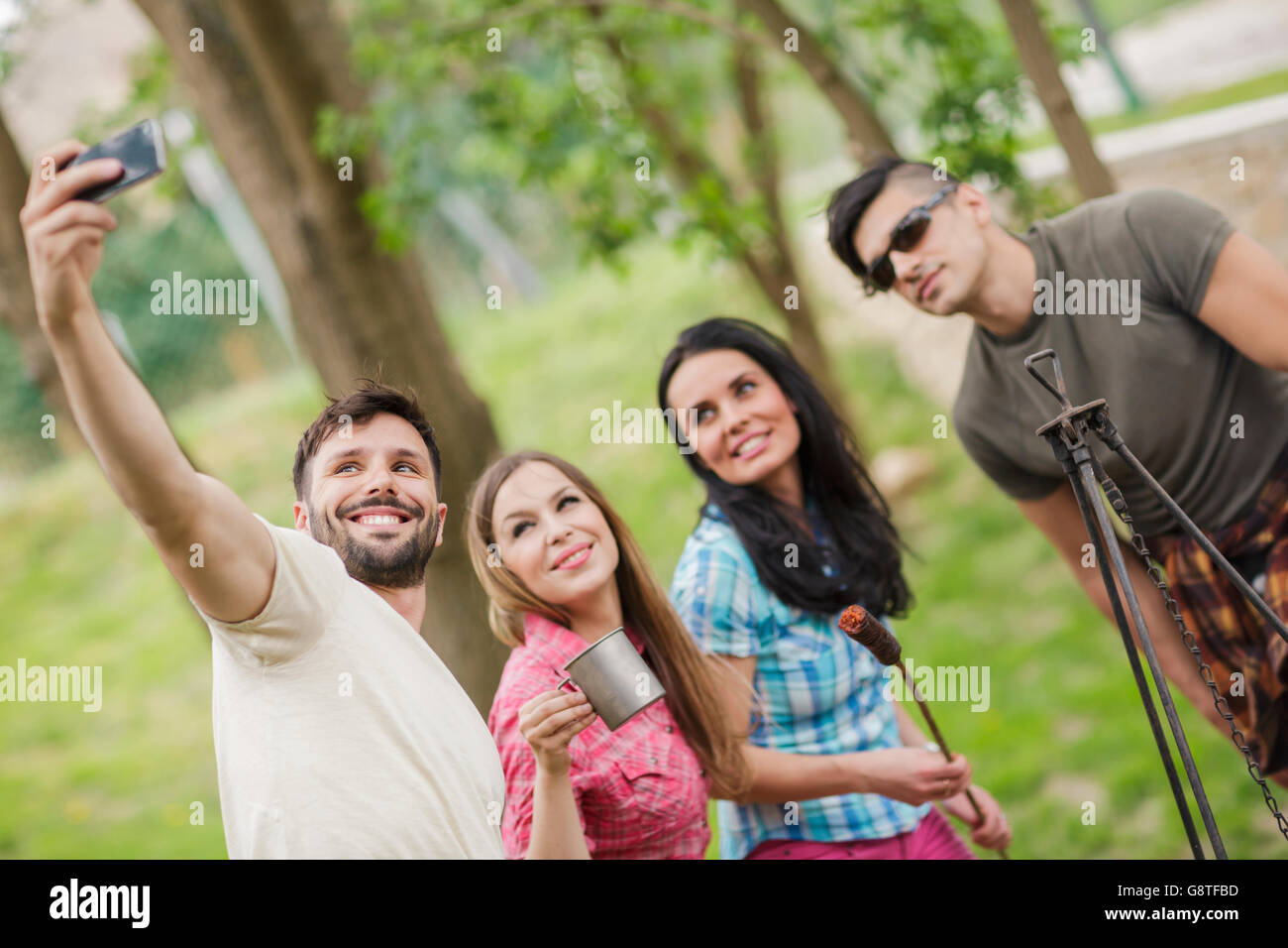 Grupo de amigos tomando selfies en camping Foto de stock