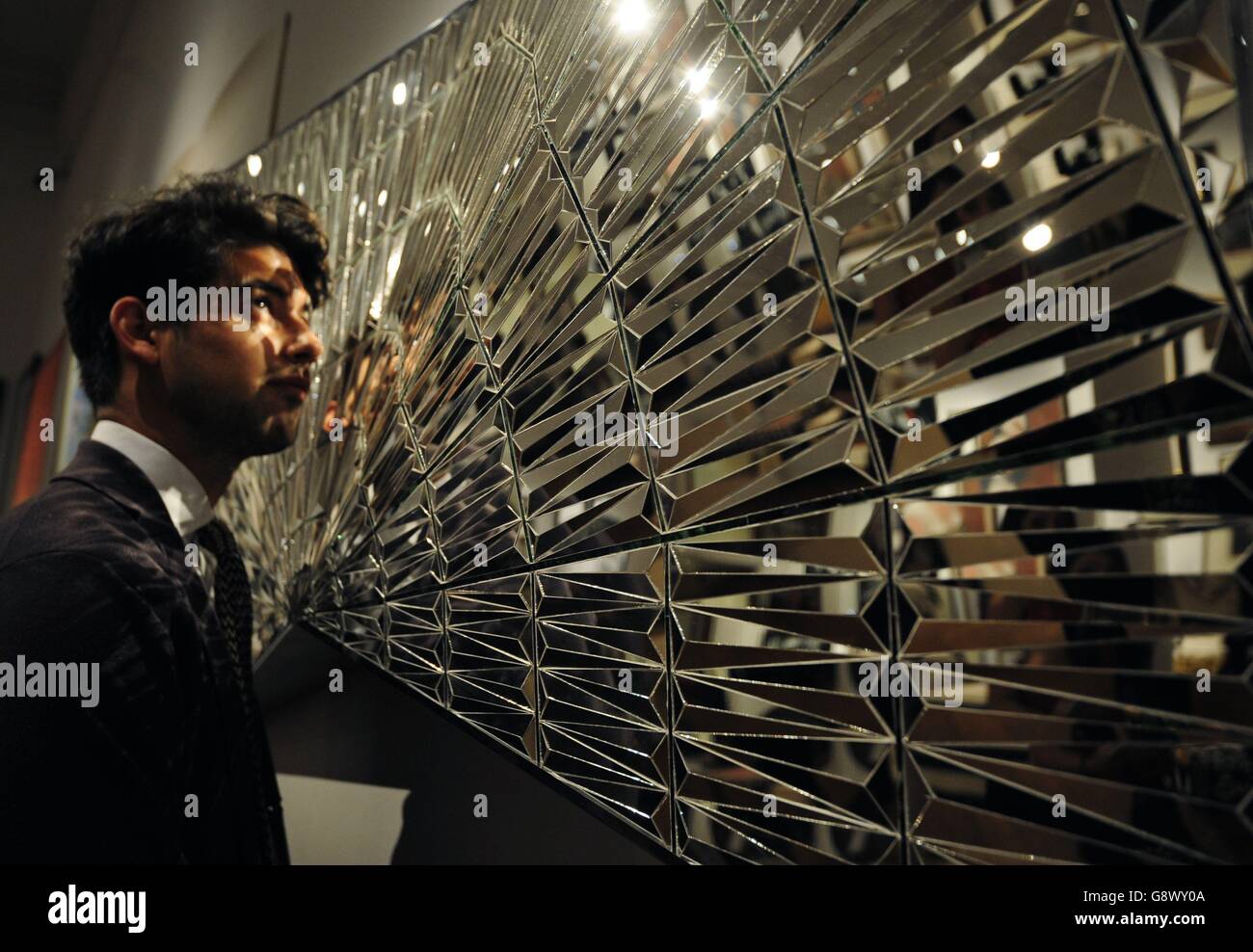 Un empleado de Sotheby examina Untitled (Faravahar Wings, Zaratustra) de Monir Shahroudy Farmanfarmaian, que se calcula entre £100.000 y 120.000 libras esterlinas, durante una llamada fotográfica para su próxima venta de un milenio de arte de Oriente Medio en New Bond Street en Londres. Foto de stock