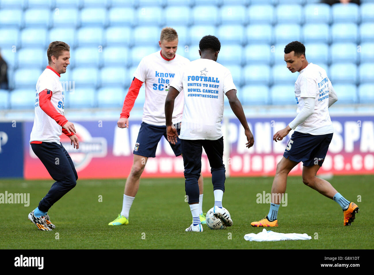 Los jugadores de Coventry City llevan "Uunites de fútbol para vencer el cáncer de intestino" camisetas durante el calentamiento Foto de stock