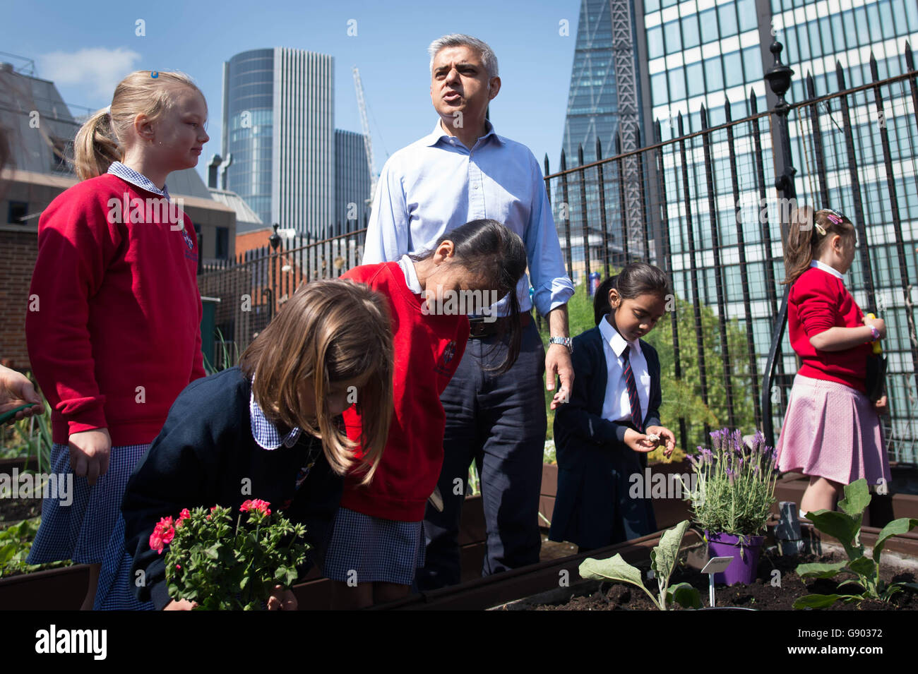 El recién elegido alcalde de Londres, Sadiq Khan, se reúne con alumnos en la escuela primaria de la Fundación Sir John Cass en la ciudad de Londres, donde ayudó a los niños a plantar semillas y flores en su jardín de techo verde después de ver una estación de vigilancia de la contaminación del aire en el patio de recreo. Foto de stock