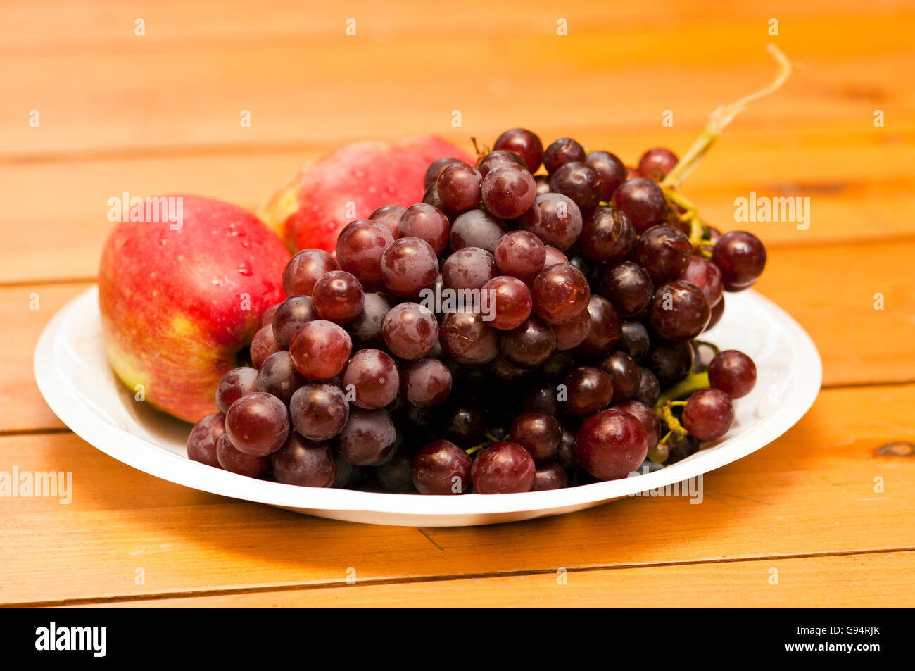 Plato de fruta de manzana y de uva Foto de stock