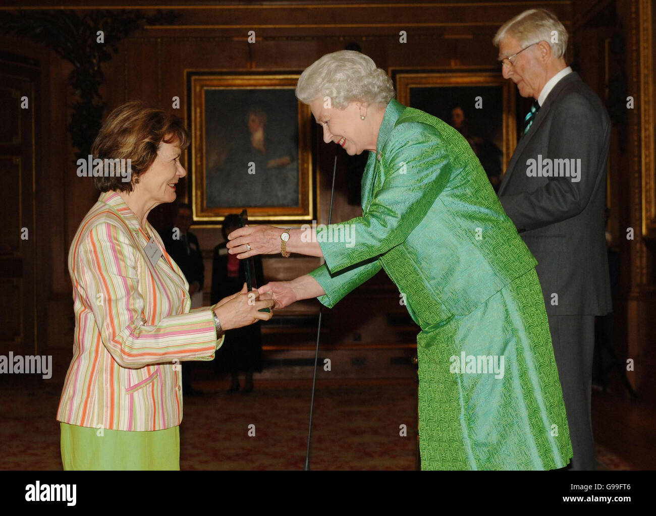 La Reina Isabel II presenta el premio Help the Aged Living Legend Media a la emisora, presentador y periodista Joan Bakewell, durante una ceremonia en el Castillo de Windsor, mientras que Michael Parkinson (derecha) también estuvo presente como presentador. Foto de stock