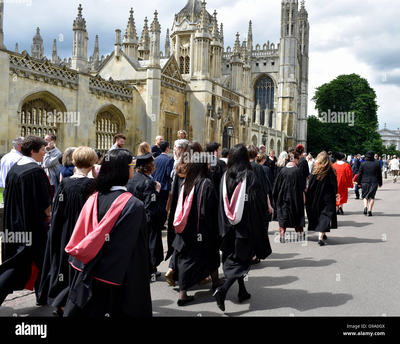 Un desfile de estudiantes de la Universidad de Cambridge Newnham pasan por el Kings College, en su camino a la graduación en la cámara del Senado Foto de stock