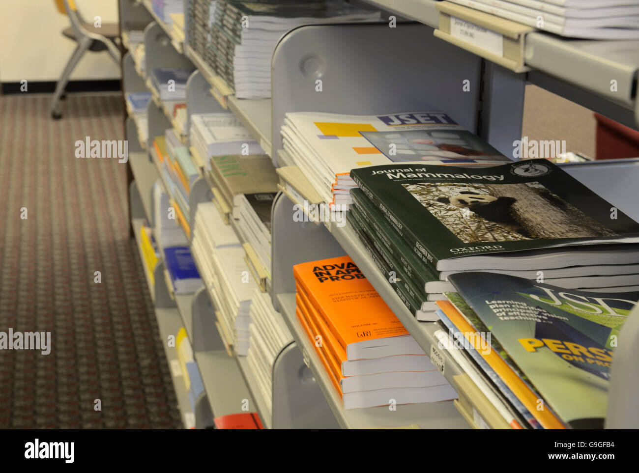 Revistas, publicaciones periódicas en las estanterías, en la biblioteca de la universidad Foto de stock