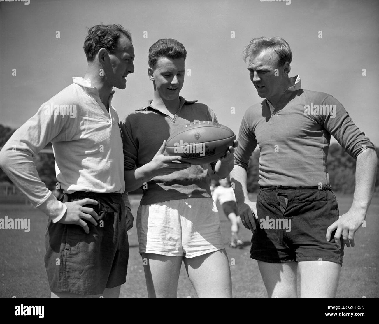 (L-R) Frank Sykes, Cecil Pedlow y Ray Williams, de los Leones británicos, hablan de los méritos del balón enviado desde Sudáfrica para familiarizar a los Leones con el equipo que utilizarán en su próxima gira Foto de stock