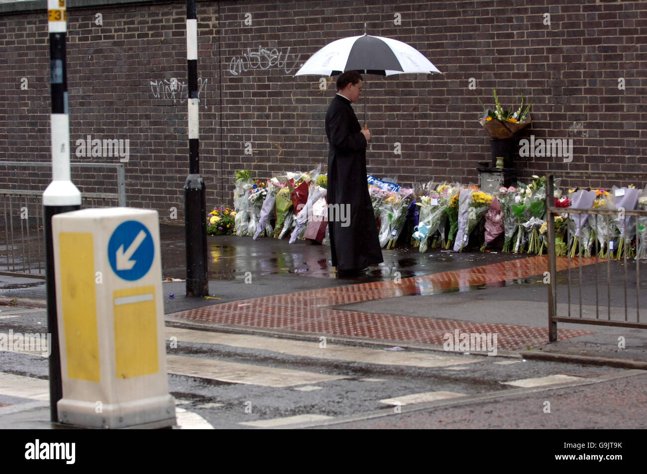 Un clérigo observa las flores que se han colocado en la escena del accidente de "hit and run" del viernes pasado en el sur de Londres, que mató a Billy Donnelly, de 19 meses de edad. Su hermano Luke, de 10 semanas, sobrevivió. Foto de stock