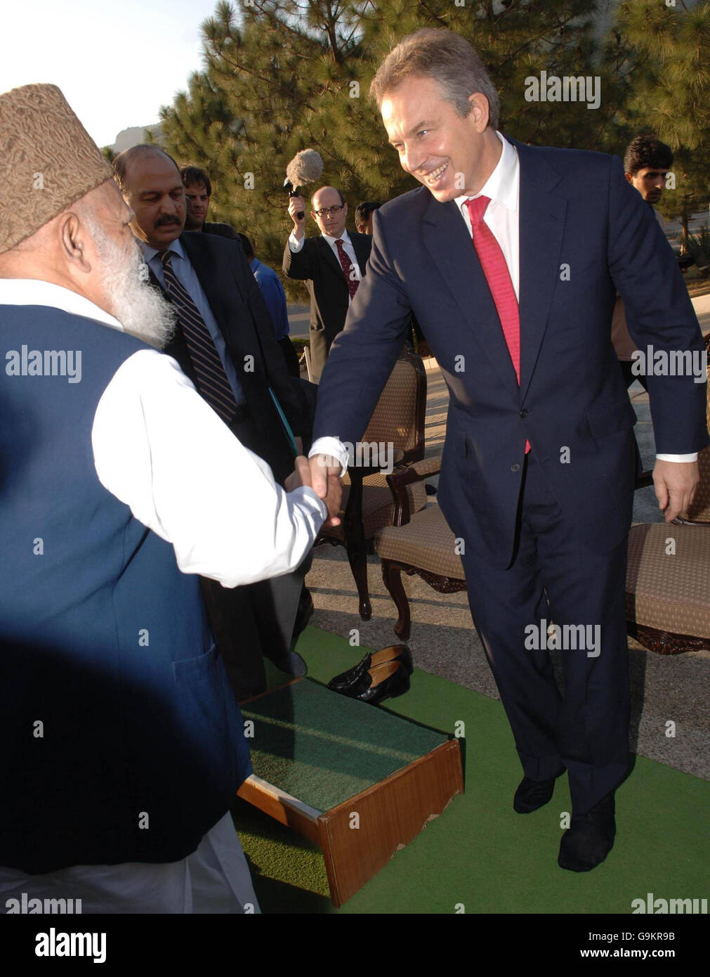 El Primer Ministro británico Tony Blair se quita el calzado antes de reunirse con los líderes musulmanes en la Mezquita Faisal en Islamabad el segundo día de su viaje a Pakistán. Foto de stock