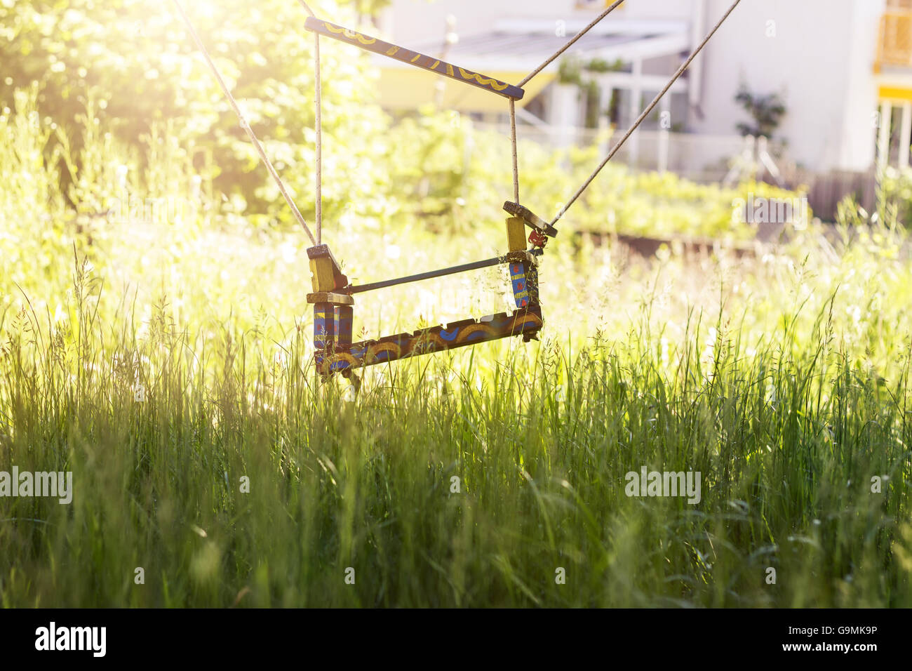 Abandonada swing en hierba alta en la temporada de primavera Foto de stock