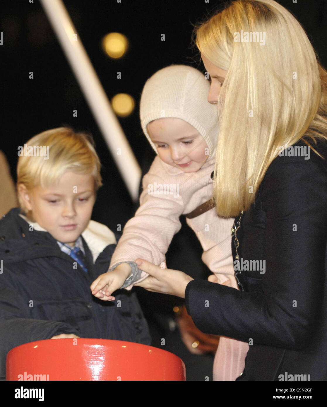 Visto por su hermano mayor, el príncipe Sverre Magnus, a la izquierda, la princesa Ingrid Alexandra de Noruega, de 2 años, es ayudado por su madre, la princesa de la corona Mette-Marit de Noruega, para encender las luces del árbol de Navidad en Trafalgar Square en Londres. Foto de stock