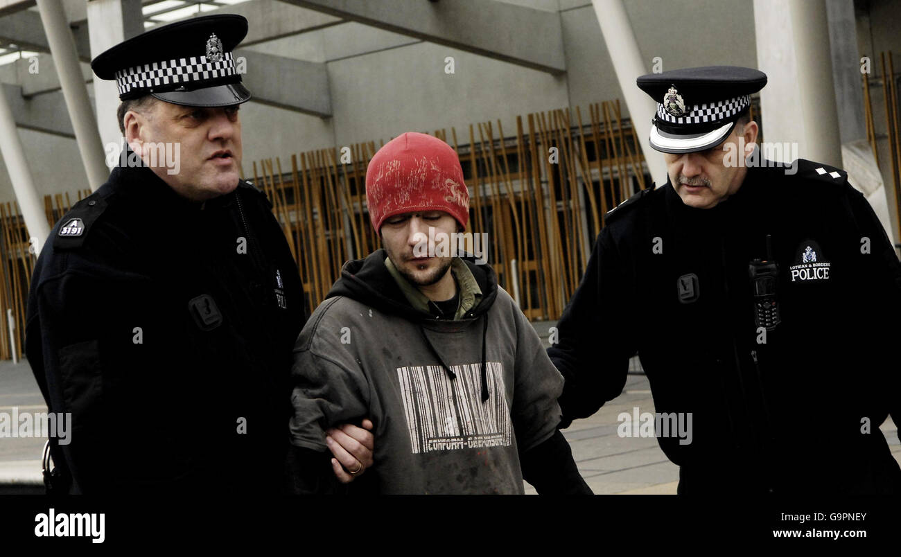 Decisión de sustitución de Trident. Un protestor anti Trident es alejado por la policía fuera del parlamento escocés en Edimburgo. Foto de stock