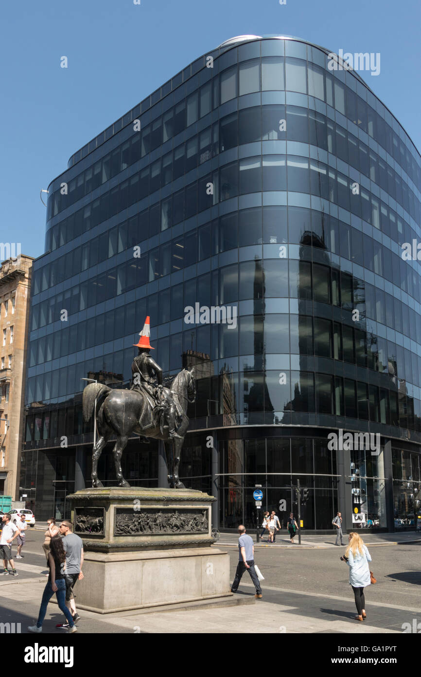 Estatua del Duque de Wellington, con cono de tráfico en la cabeza, contra el bloque de oficinas moderno en Glasgow, Escocia, Reino Unido, Foto de stock