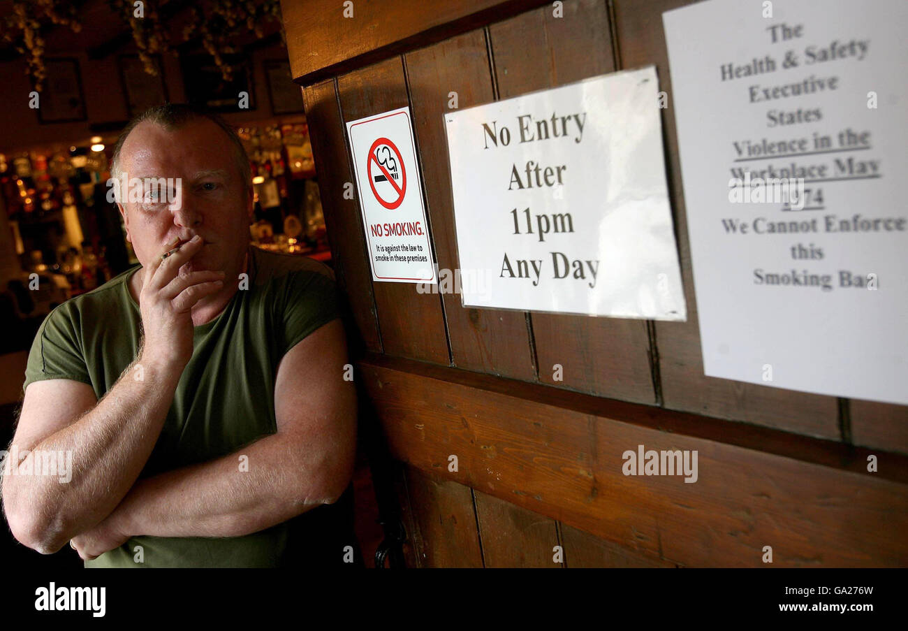 Tony Blows, propietario del Dog Inn en Ewyas Harold cerca de Hereford, desafía abiertamente la prohibición de fumar y fuma dentro de la casa pública el primer día de la prohibición de fumar. Foto de stock