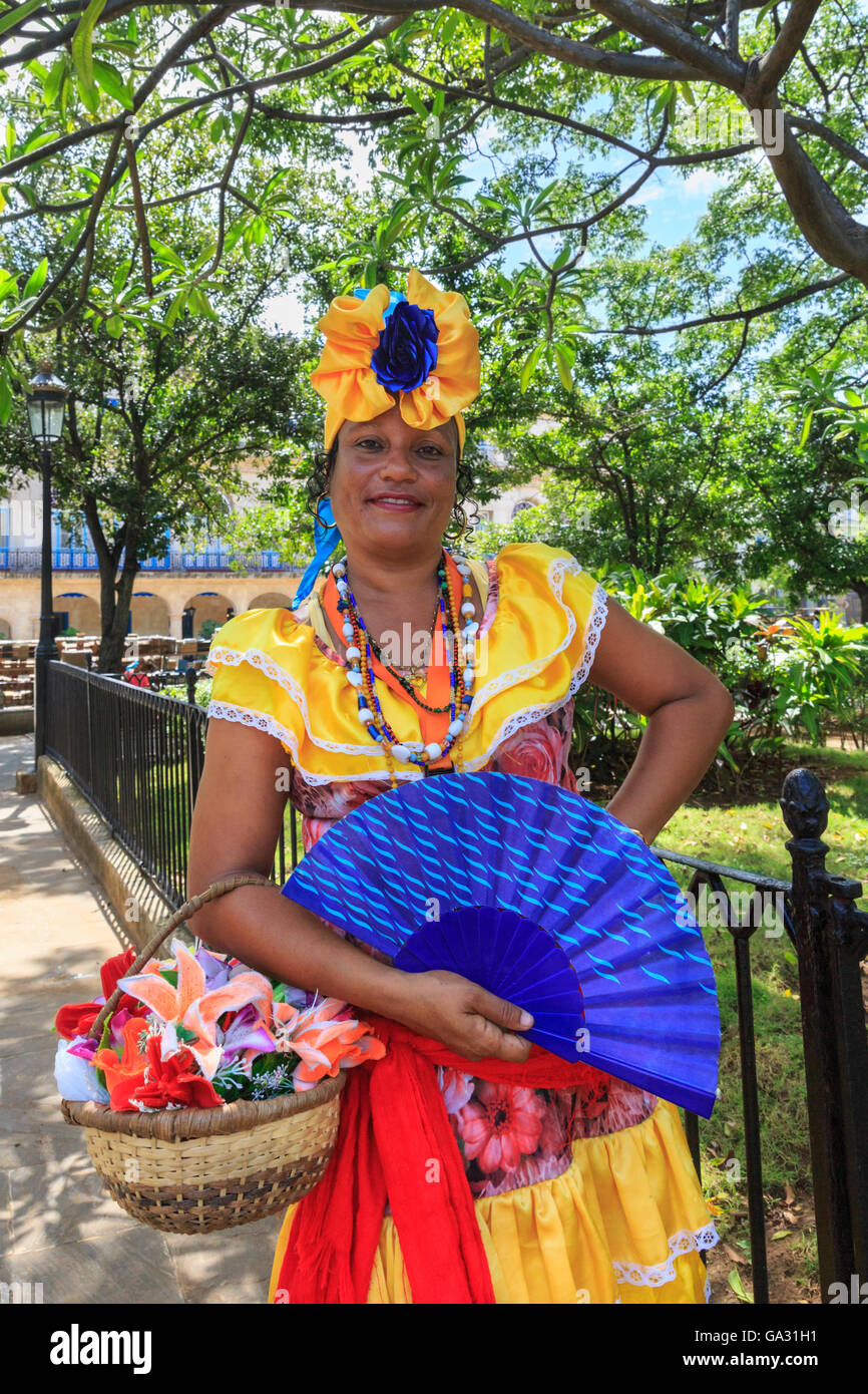 En coloridos vestidos mujer cubana plantea, en la Plaza de Armas, La Habana  Vieja, La Habana Vieja, Cuba Fotografía de stock - Alamy