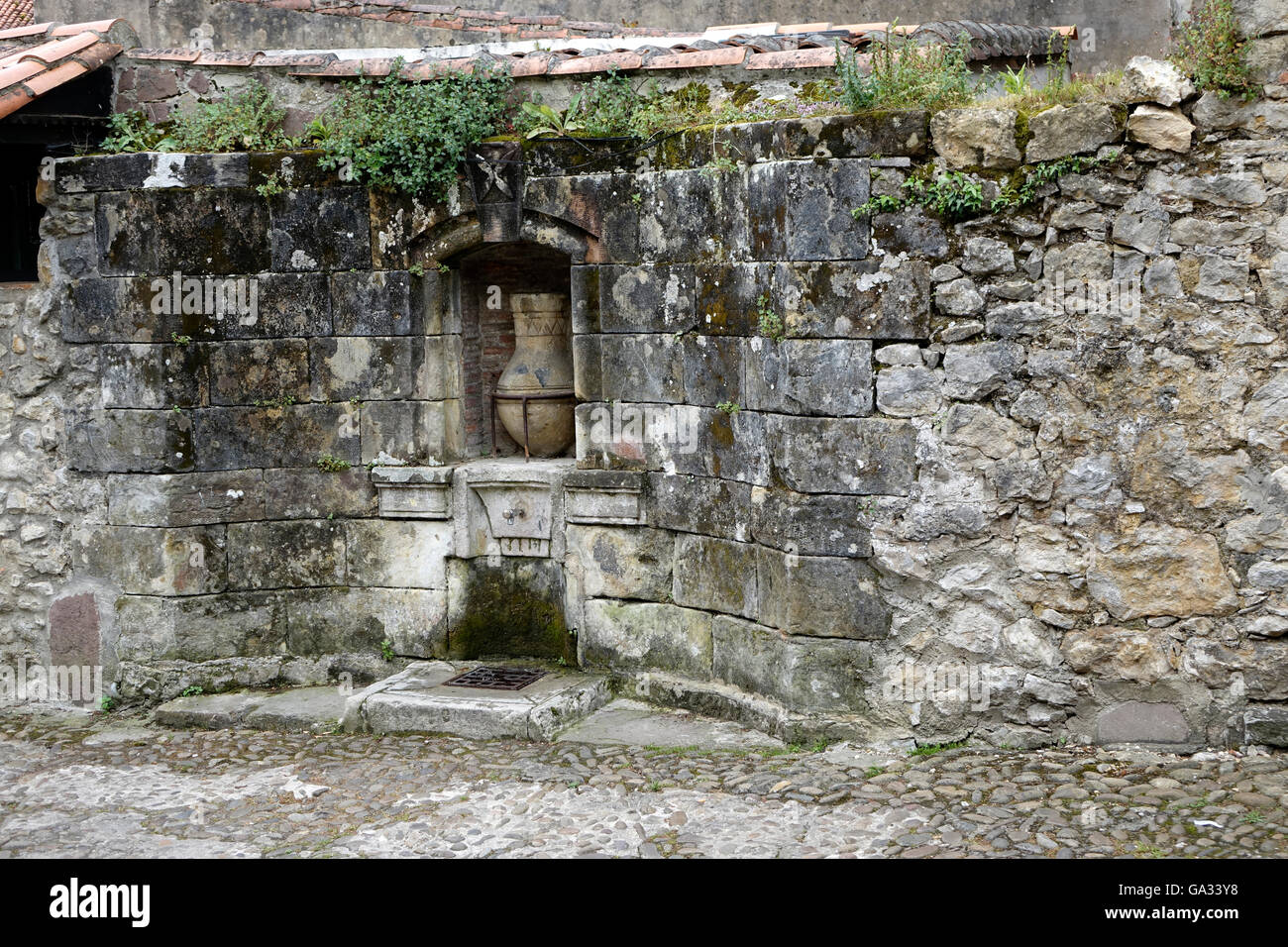 Una cisterna de agua pública en Santillana del Mar en el norte de España, ha sido utilizado por los lugareños para cientos de años para agua potable fresca Foto de stock