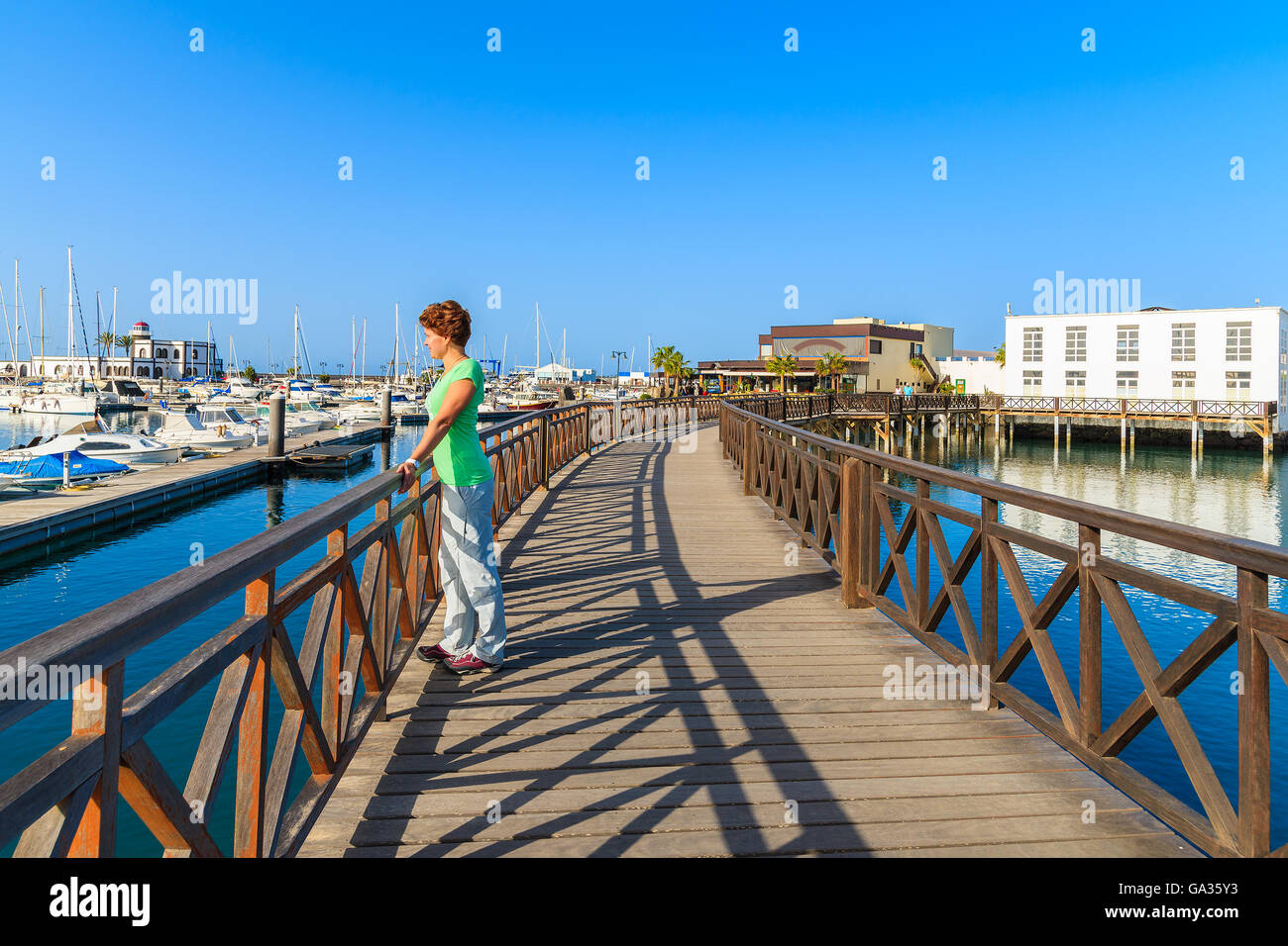 Joven turista pararse en la pasarela de Rubicon puerto de yates. Isla de Lanzarote, ESPAÑA Foto de stock
