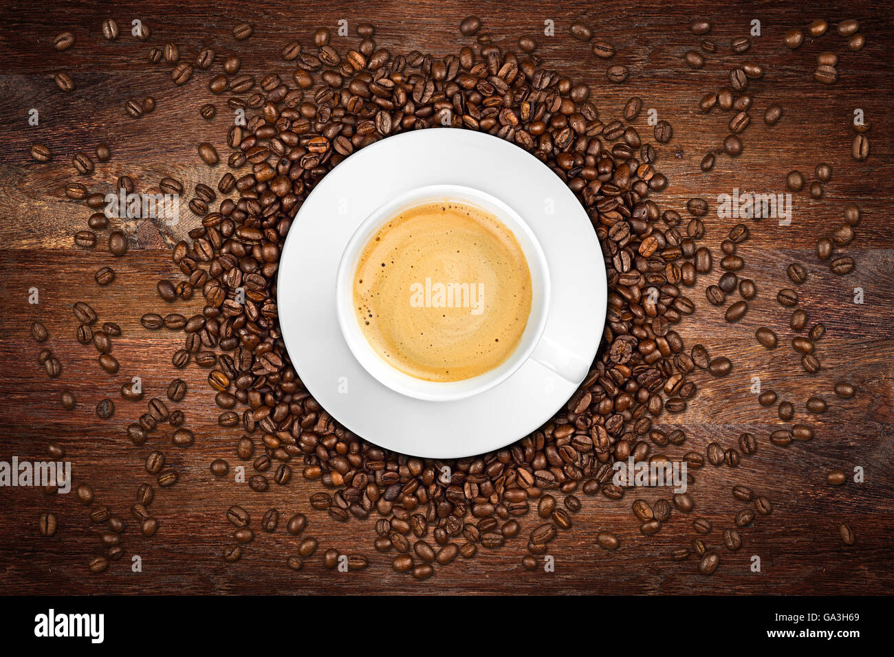 Taza de café y frijoles en roble rústico antecedentes Foto de stock