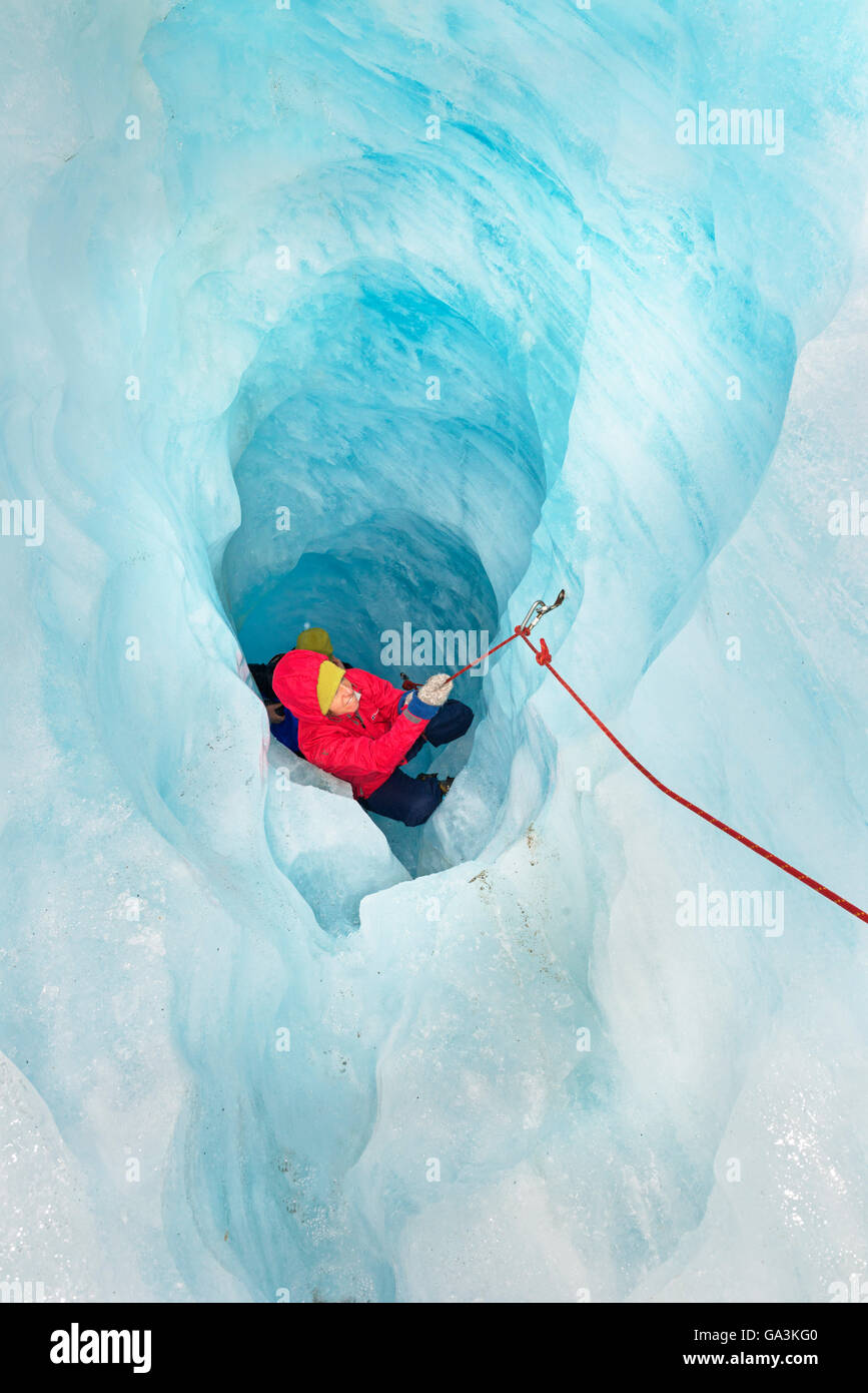 Escalador sube la cueva de hielo, el glaciar Fox, Isla del Sur, Nueva Zelanda Foto de stock