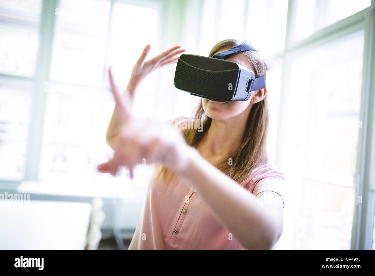 Diseñador gráfico realizando acciones de mano mientras usa casco de realidad virtual Foto de stock