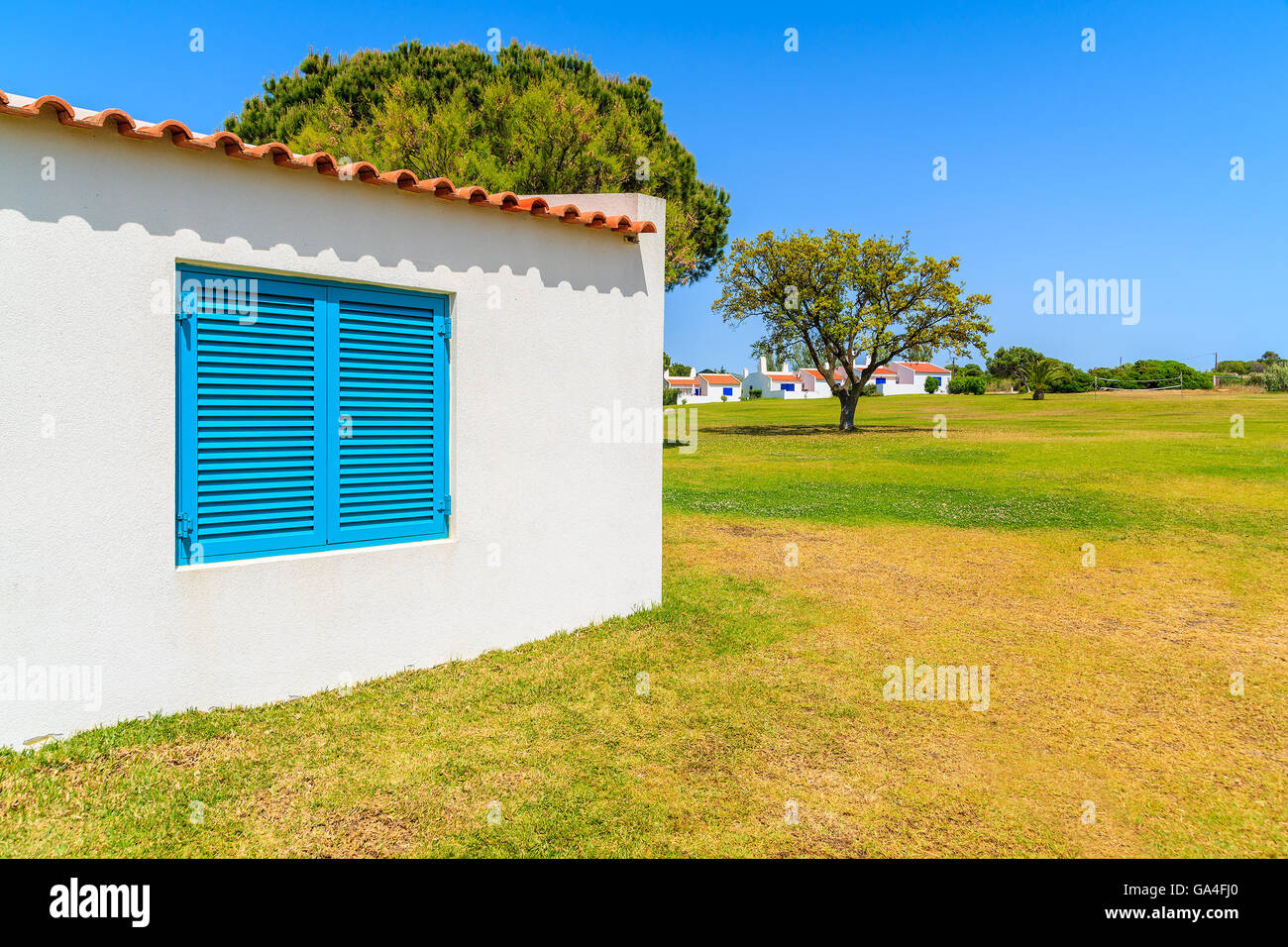 Jardín con la típica casa de vacaciones en la ciudad de Alvor, Algarve, Portugal Foto de stock