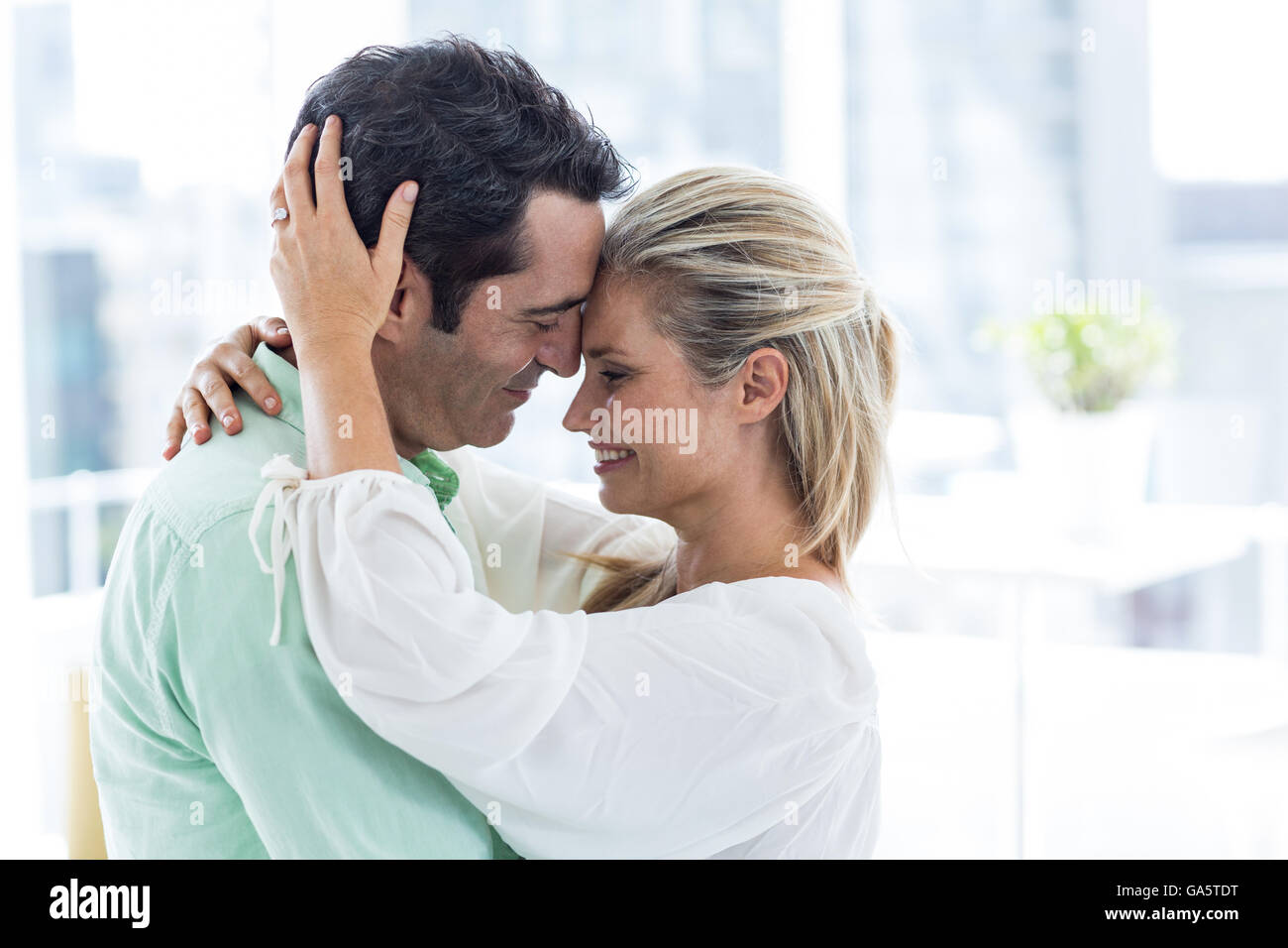 Romántica pareja abrazada en casa Foto de stock