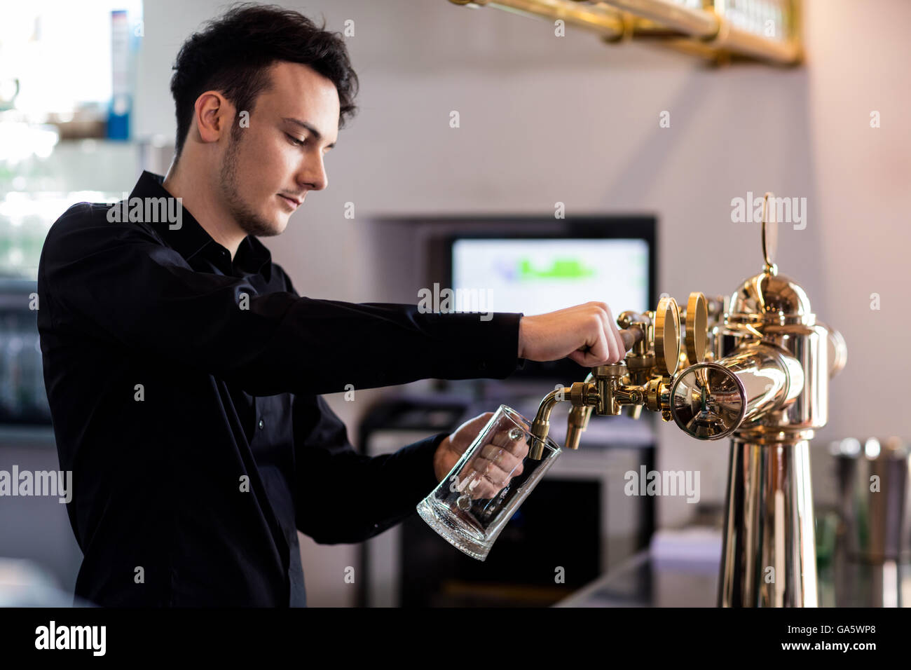 Bartender derramar cerveza de grifo de vidrio Foto de stock