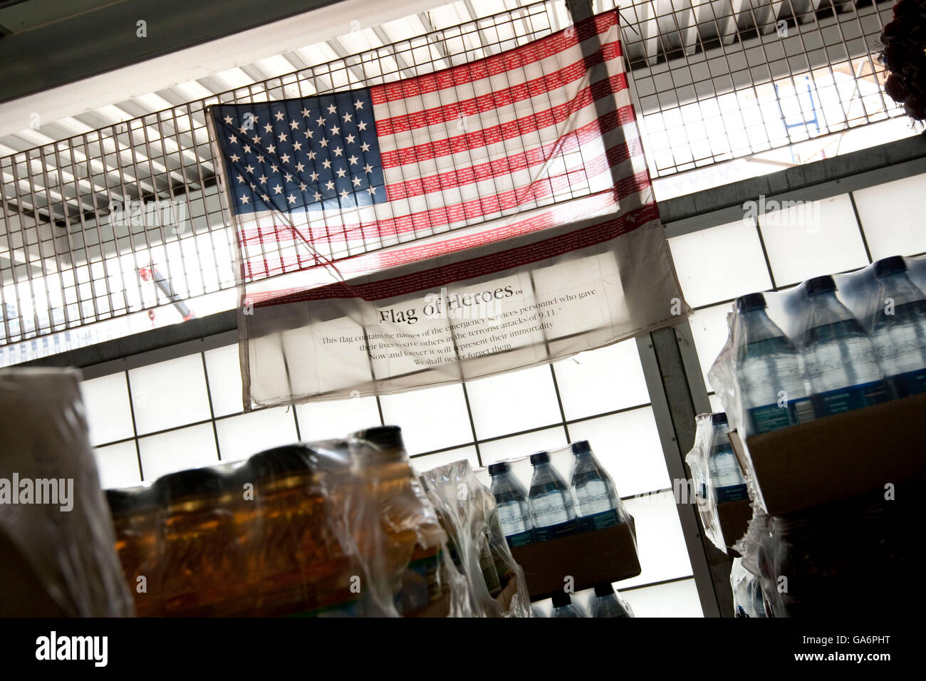 Una bandera americana marcados con los nombres de todos los servicios de emergencia personal que murieron en los ataques terroristas del 11 de septiembre, se cuelga en un rai Foto de stock