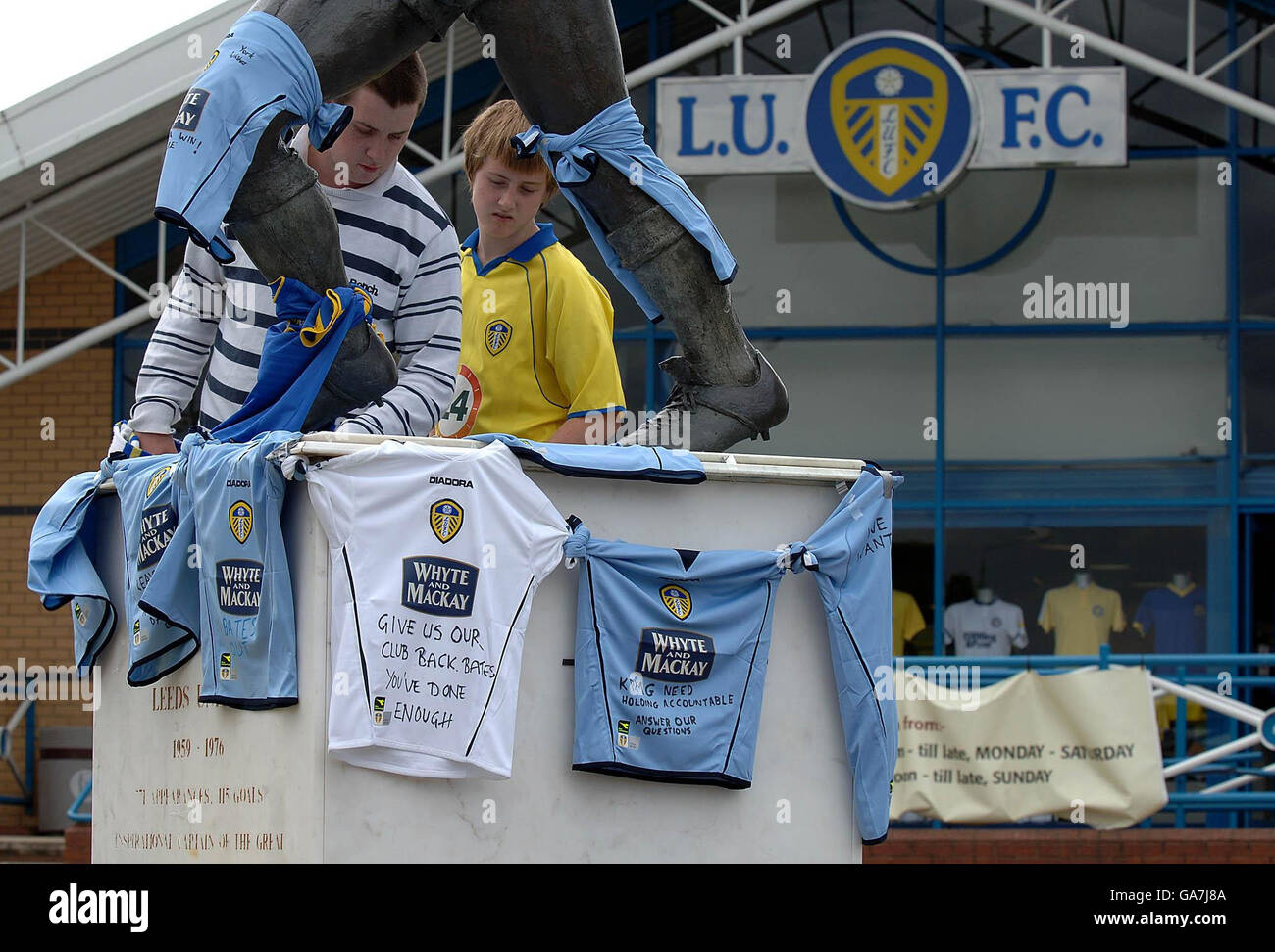 Los seguidores de Leeds United colocan camisetas de equipo con mensajes alrededor de la estatua de Billy Bremner en Elland Road, Leeds. Foto de stock